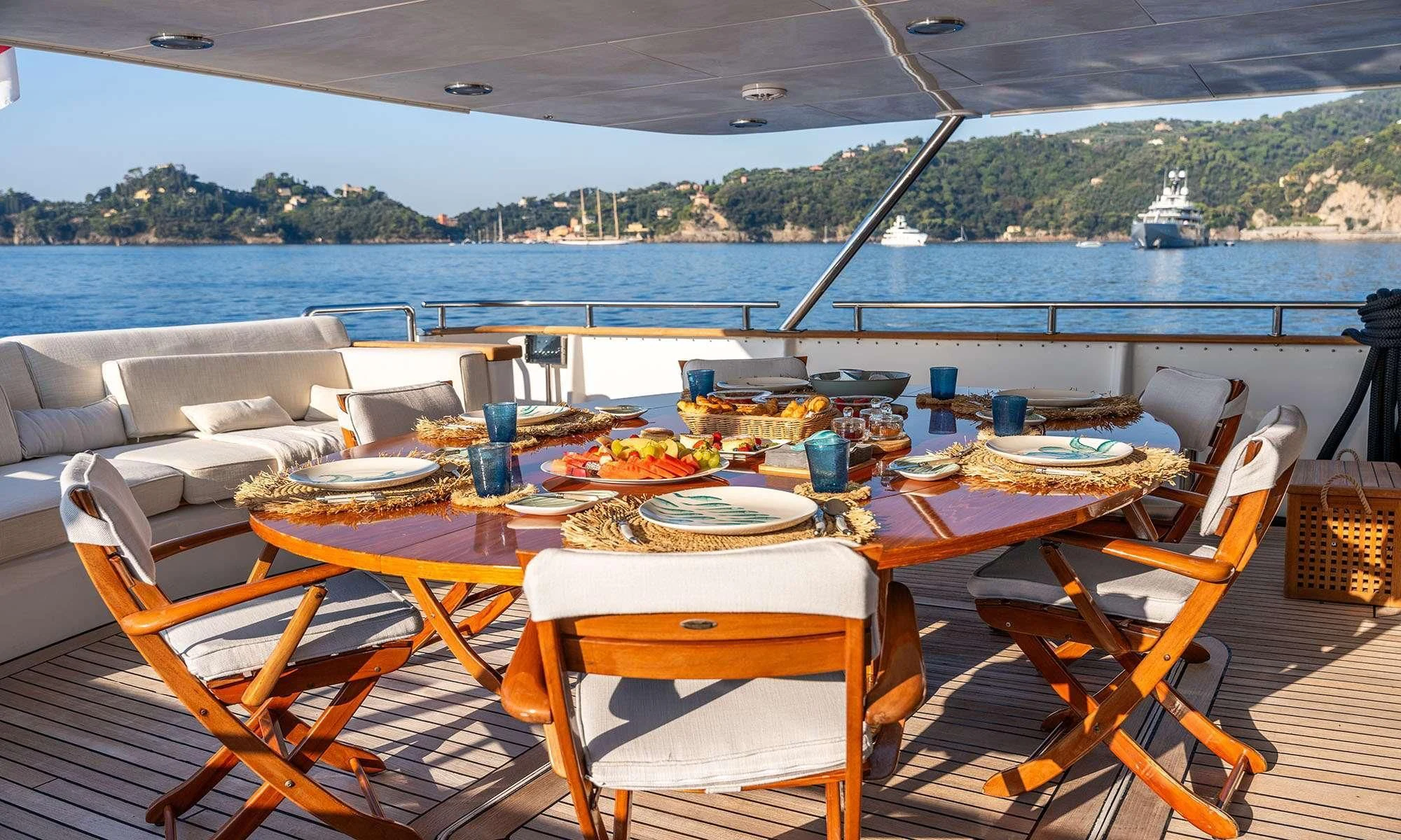 a table set for a meal on a deck overlooking a body of water aboard SEA LADY II Yacht for Sale