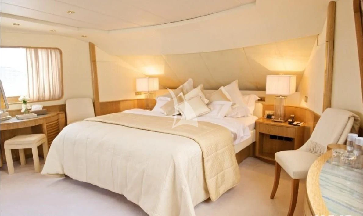 a bedroom with a bed and a chair aboard SEA LADY II Yacht for Sale