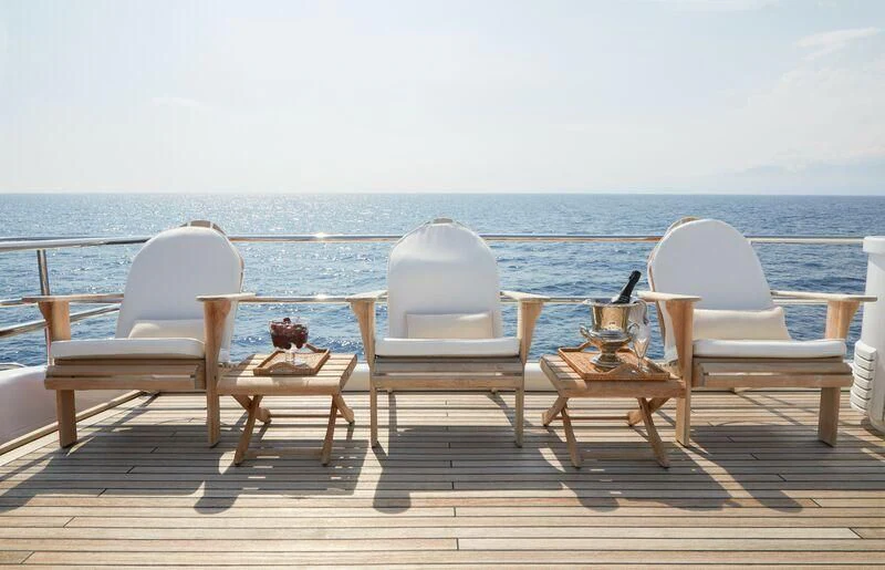 a couple of chairs and a table on a deck overlooking the ocean aboard SEA LADY II Yacht for Sale