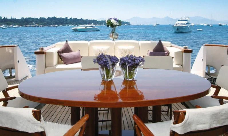 a table with chairs and flowers on it aboard SEA LADY II Yacht for Sale