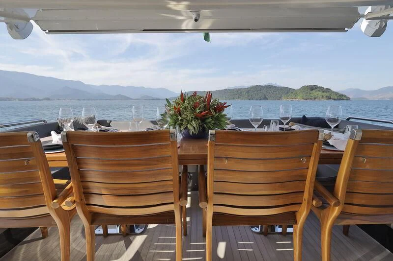 a table with chairs and flowers on it aboard OKTO Yacht for Sale