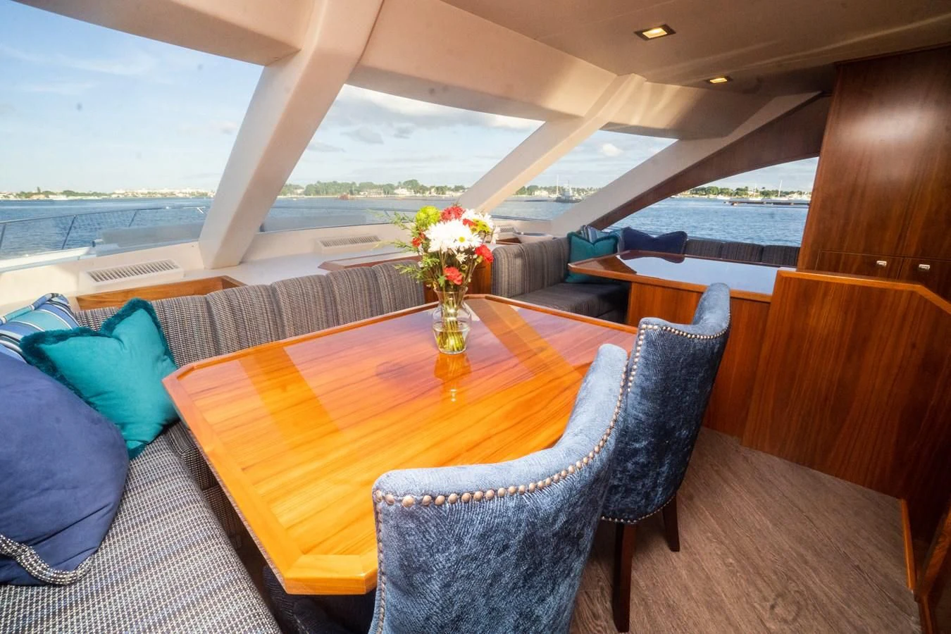 a table with chairs and a vase of flowers on it aboard KALEEN Yacht for Sale