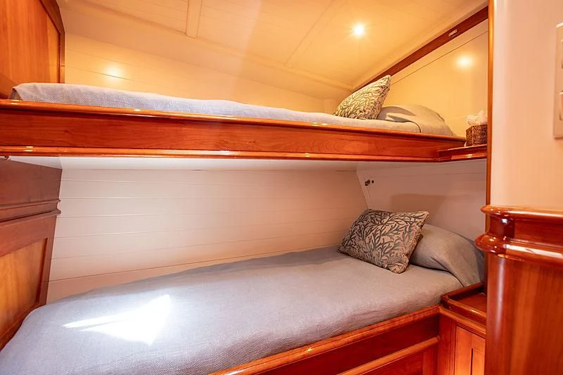 a bed with a wooden headboard aboard KEALOHA Yacht for Sale