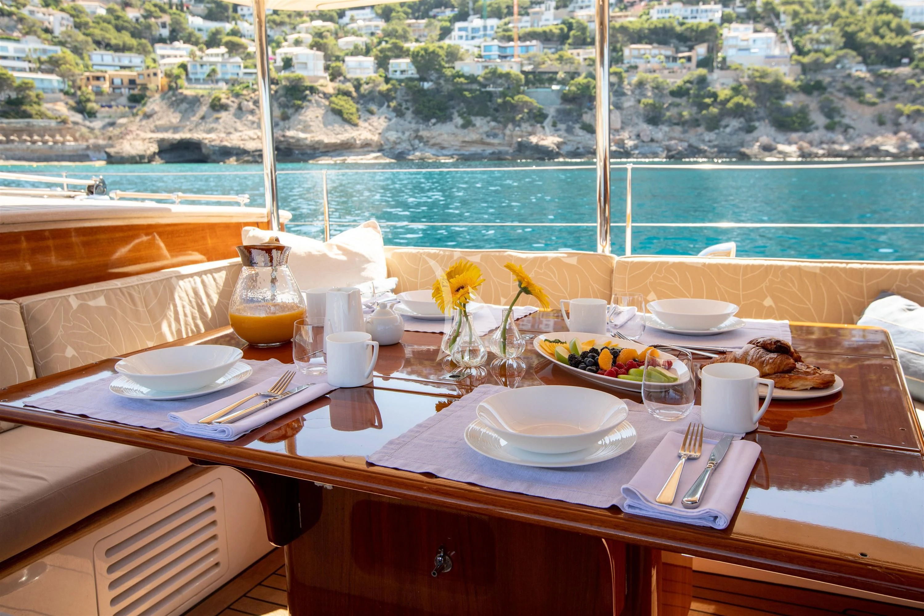 a table with plates and glasses on it aboard KEALOHA Yacht for Sale