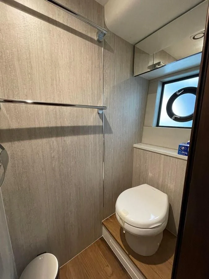 a bathroom with a toilet and a mirror aboard FAIRLINE SQUADRON 65 Yacht for Sale