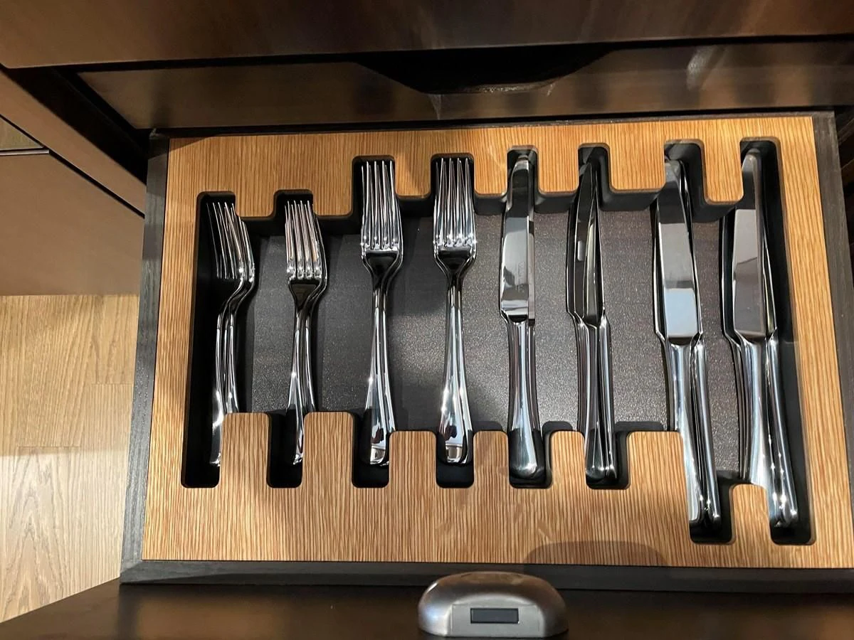 a group of silverware on a wooden surface aboard FAIRLINE SQUADRON 65 Yacht for Sale