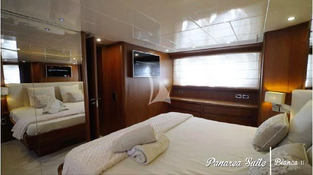 a room with a bed and a television aboard BIANCA II Yacht for Charter