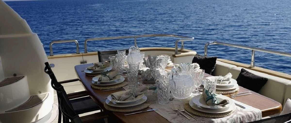a table with plates and glasses on it aboard BIANCA II Yacht for Charter