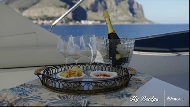 a bottle of champagne on a table aboard BIANCA II Yacht for Charter