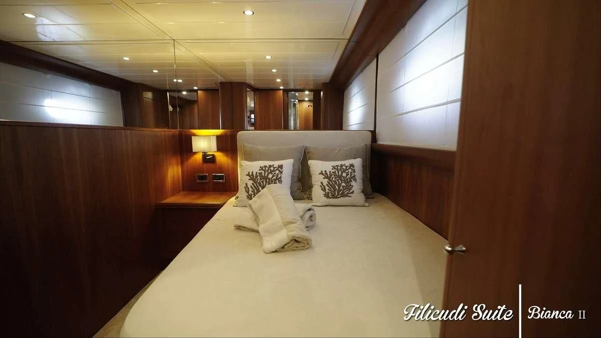 a bed with pillows on it aboard BIANCA II Yacht for Charter