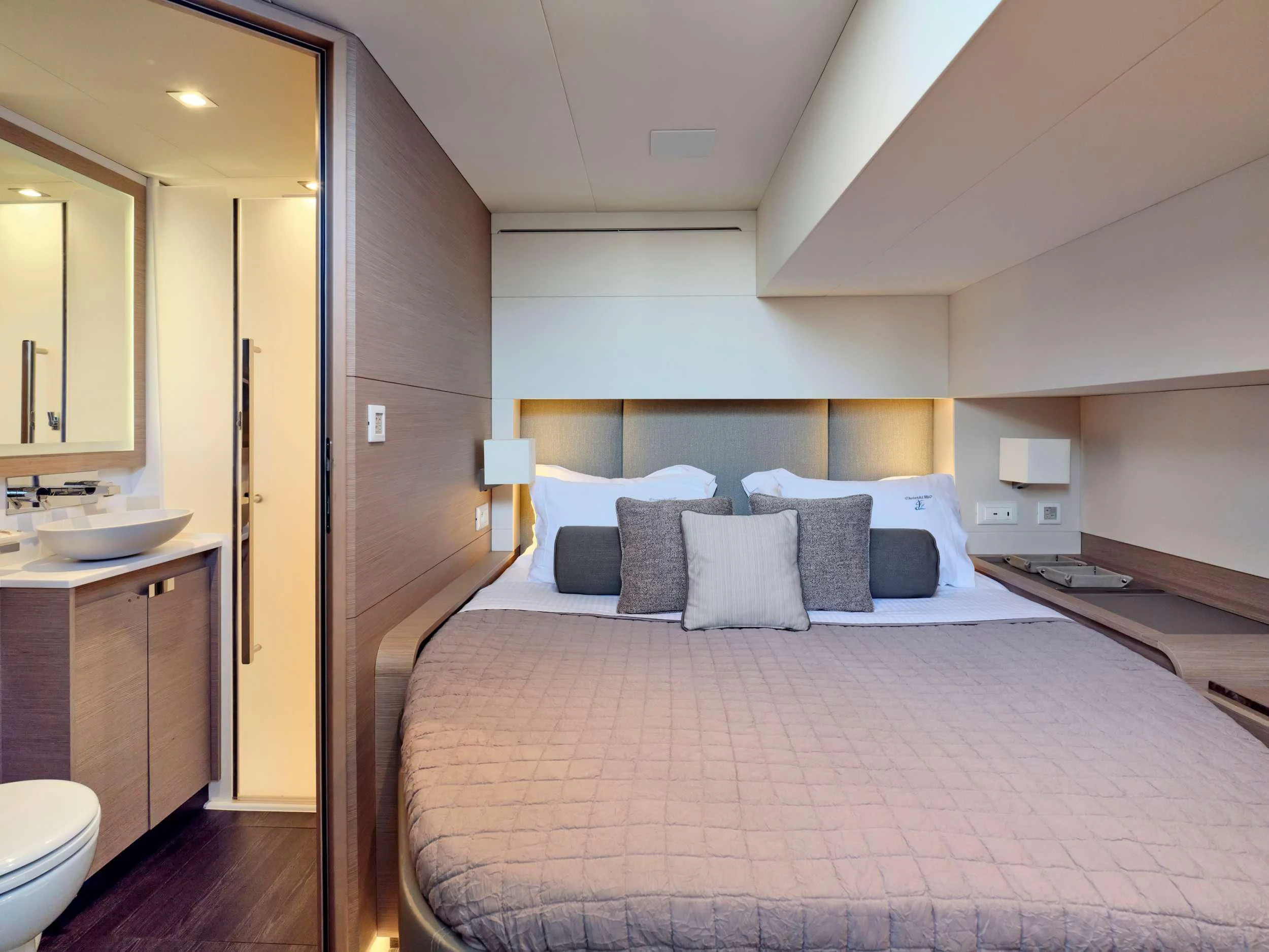 a bed with a white bed spread aboard MAJESTY OF GREECE Yacht for Charter