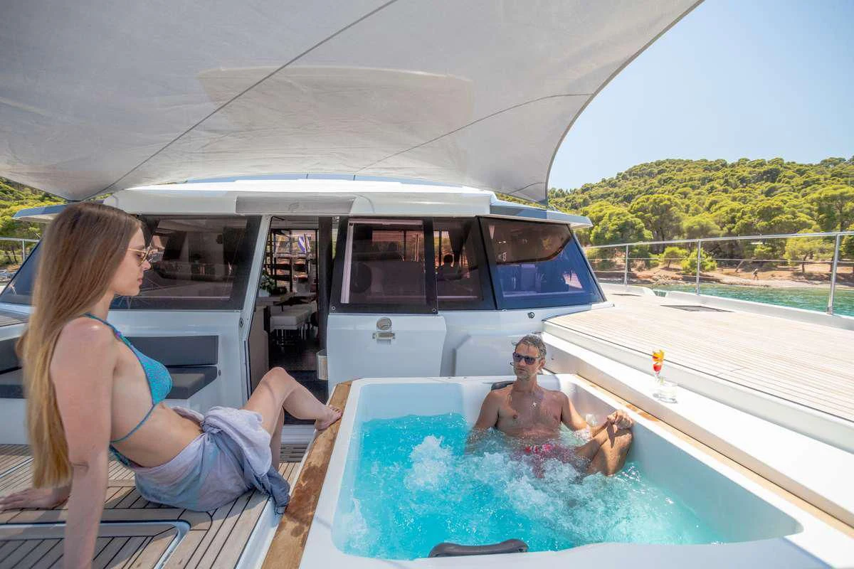 a couple of people sitting in a hot tub on a boat aboard MAJESTY OF GREECE Yacht for Charter