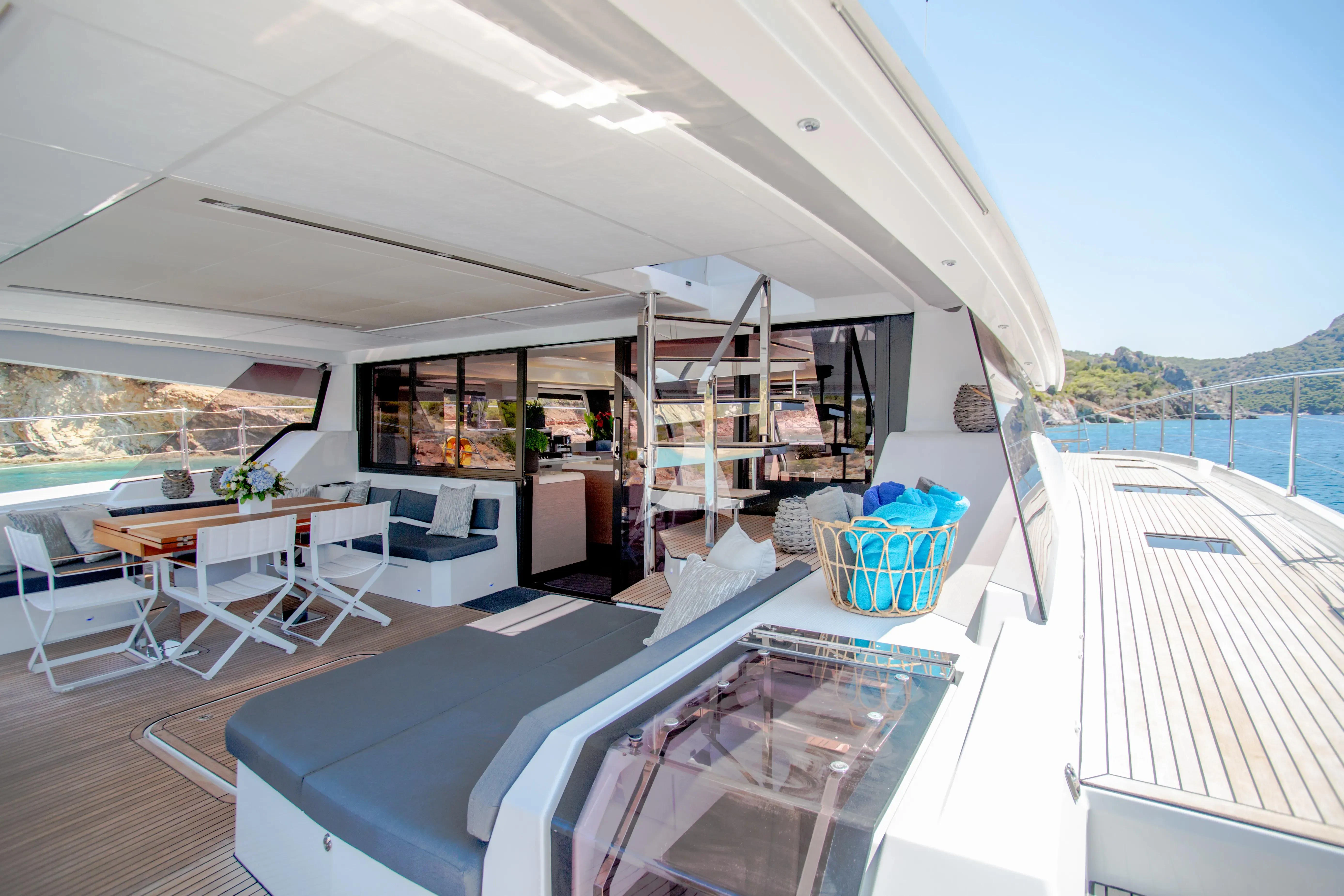 a large open area with a table and chairs and a large window aboard MAJESTY OF GREECE Yacht for Charter