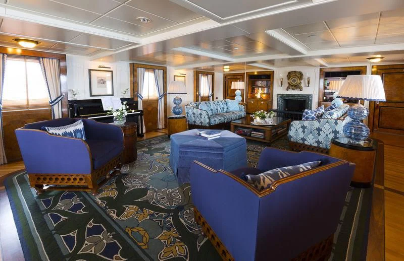 a living room with blue couches aboard TALITHA Yacht for Sale