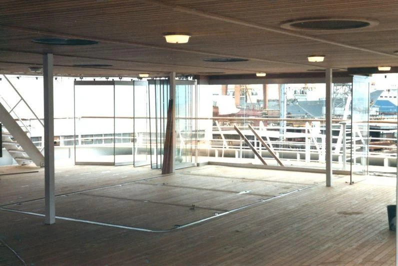 a large room with a large glass wall and a staircase aboard BASRAH BREEZE Yacht for Sale