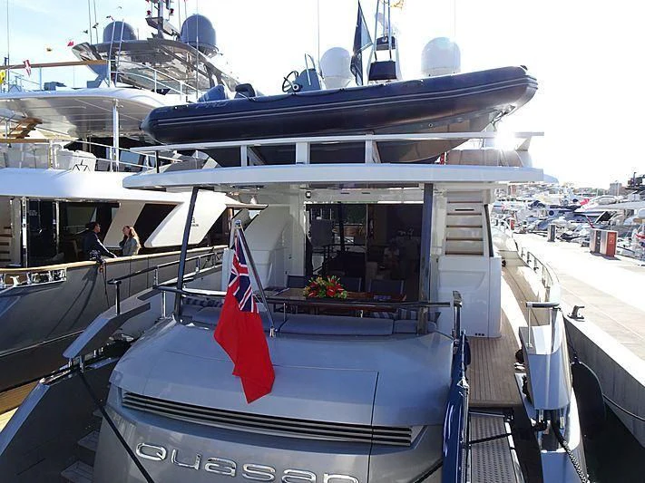 a boat with a flag on the deck aboard QUASAR Yacht for Sale