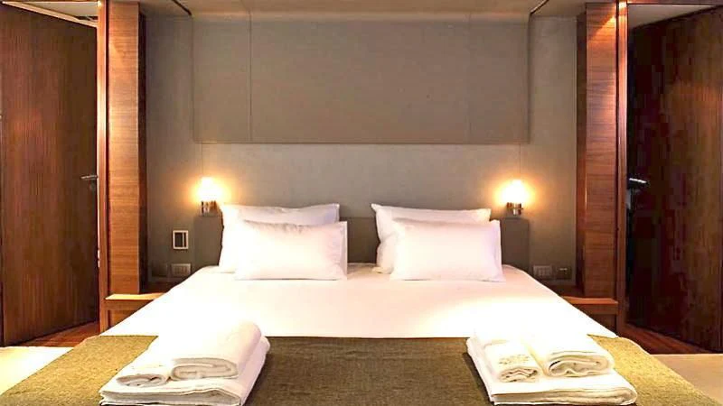 a bed with white sheets aboard QUASAR Yacht for Sale