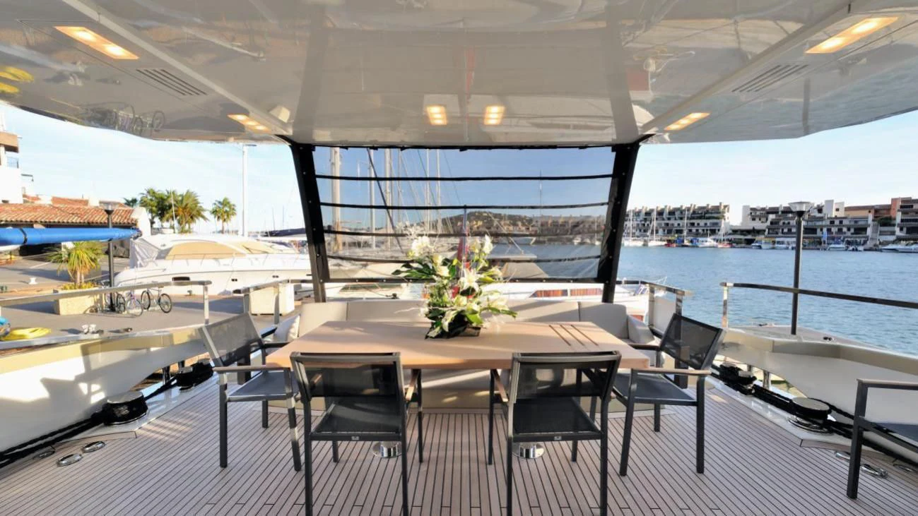 a table and chairs on a deck aboard QUASAR Yacht for Sale