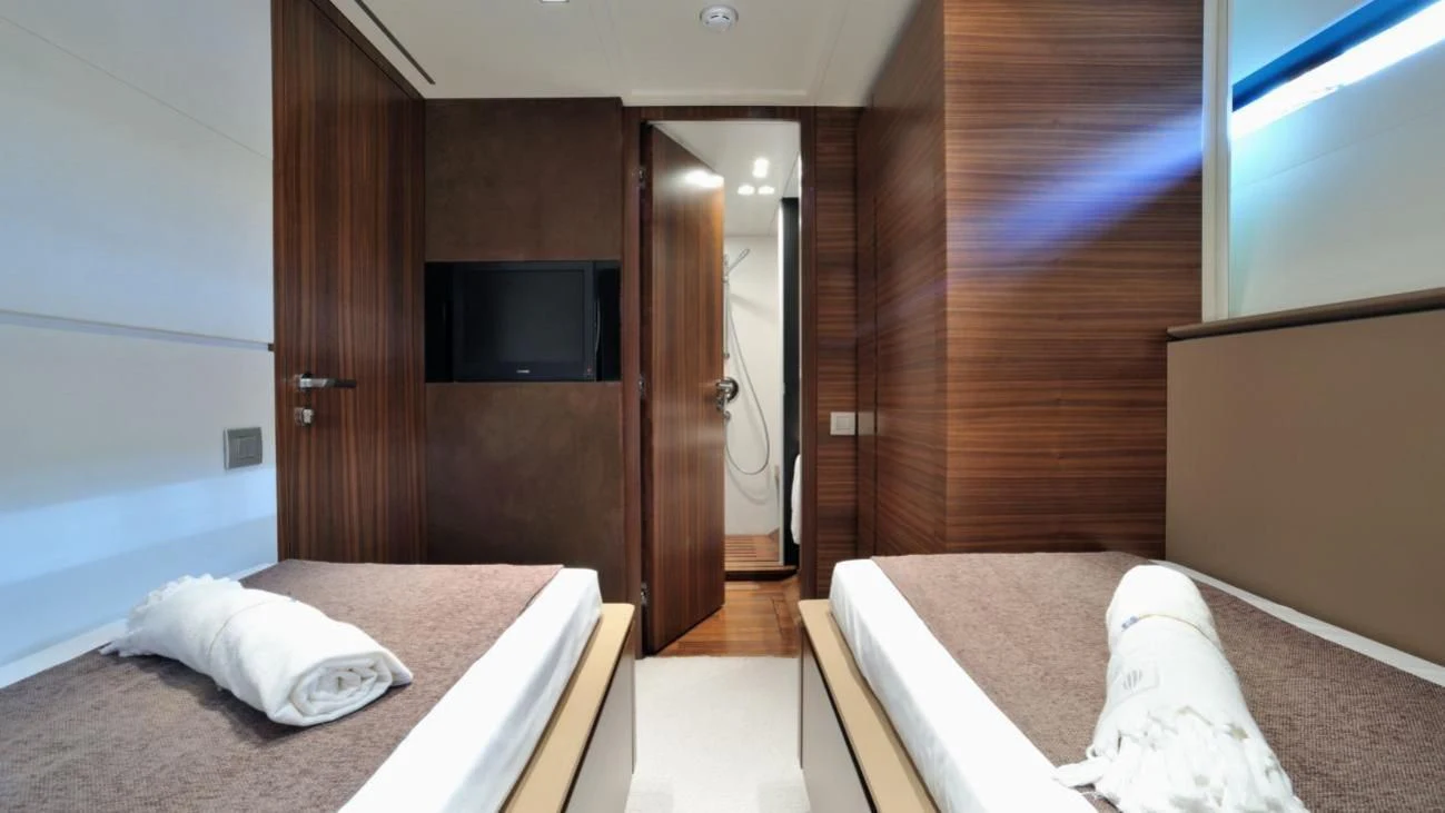 a room with a bed and a television aboard QUASAR Yacht for Sale