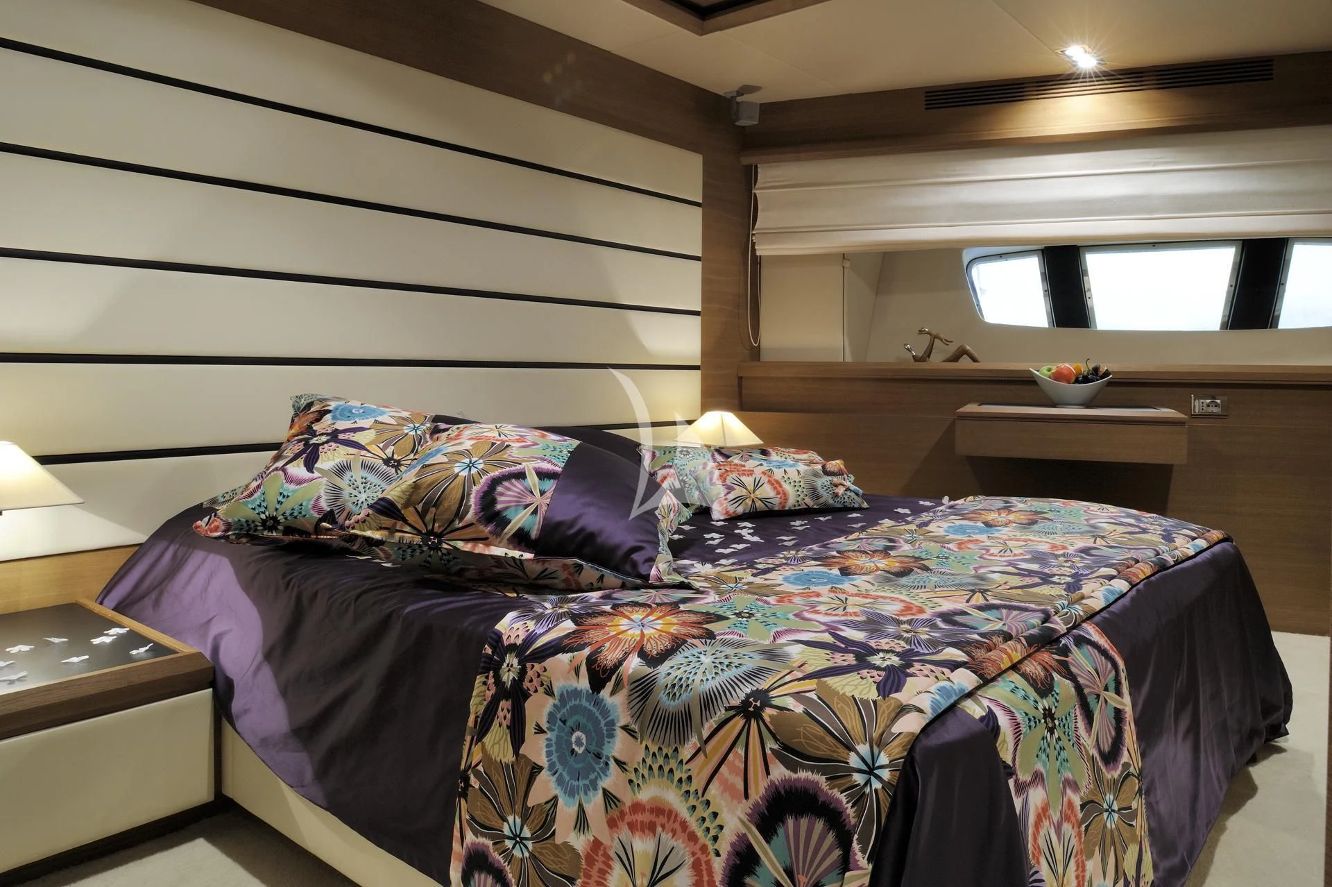 a bed with a blue comforter aboard LEONARDO 98 Yacht for Sale