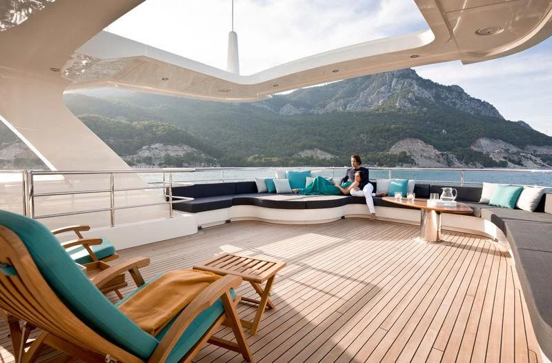 a person sitting on a deck with a laptop on the lap aboard LA PASSION Yacht for Sale