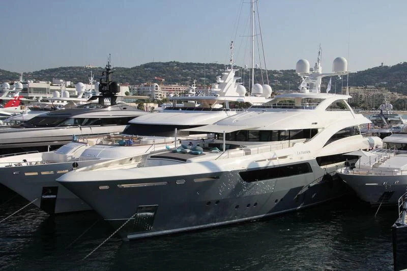 a large white yacht in a harbor aboard LA PASSION Yacht for Sale