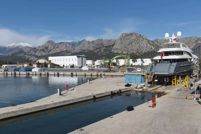 a dock with a boat and a mountain in the background aboard LA PASSION Yacht for Sale