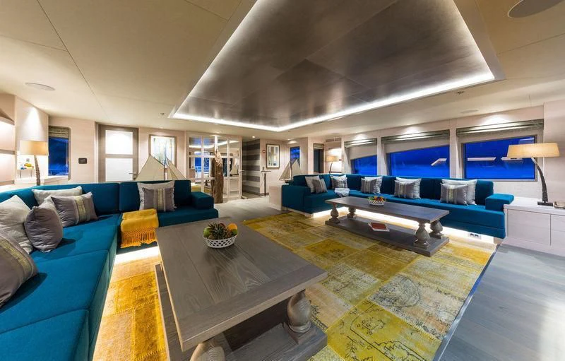 a living room with blue couches aboard LA PASSION Yacht for Sale