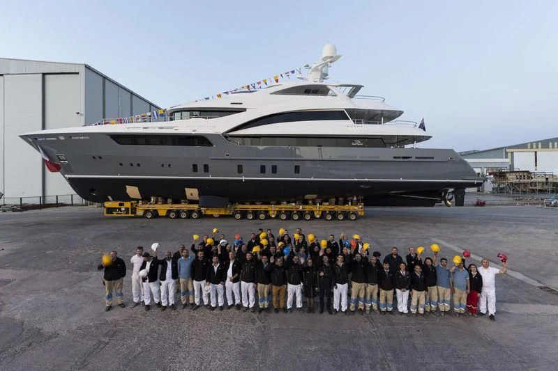 a group of people posing in front of a large ship aboard LA PASSION Yacht for Sale