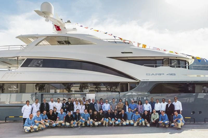 a group of people posing for a photo in front of a plane aboard LA PASSION Yacht for Sale