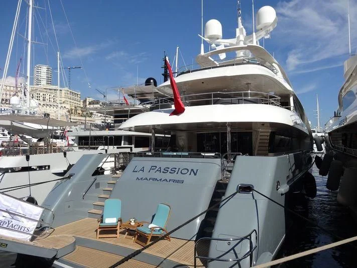 a large white boat in a harbor aboard LA PASSION Yacht for Sale