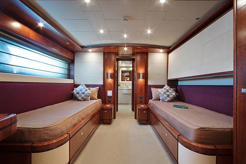 a room with beds and a mirror aboard SIMA Yacht for Sale
