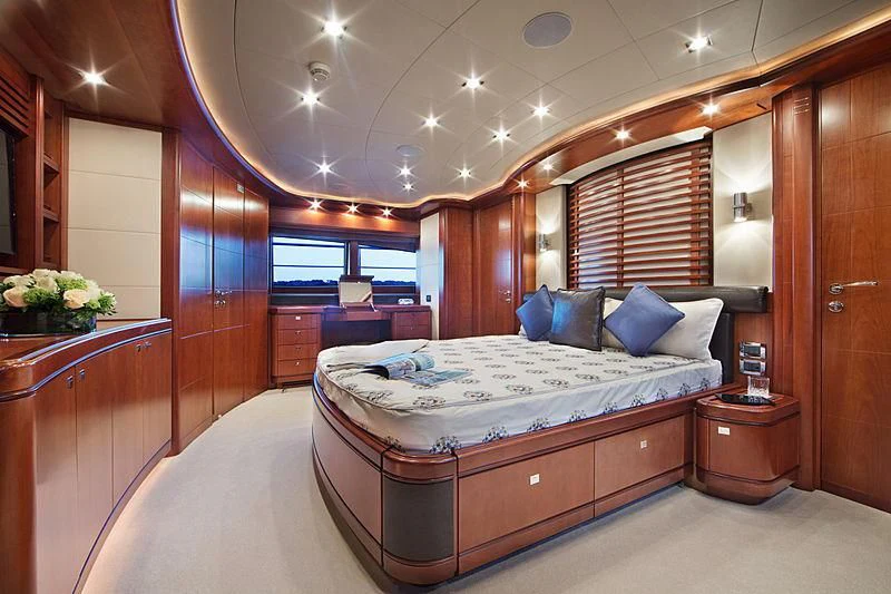 a bedroom with a bed and a desk aboard SIMA Yacht for Sale