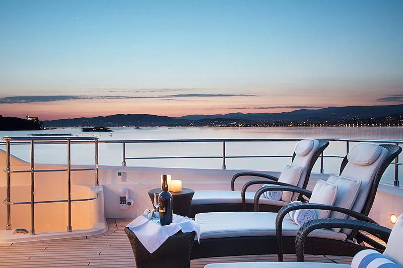 a view of a sunset over a body of water and a beach aboard SIMA Yacht for Sale