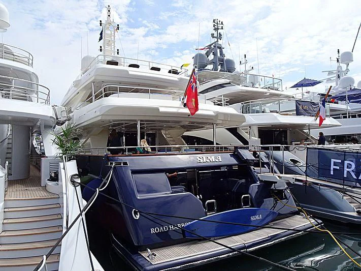a large white boat with flags on it aboard SIMA Yacht for Sale