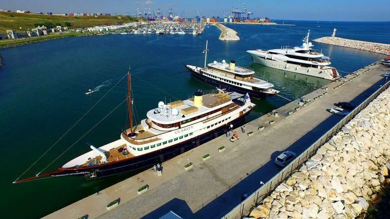 a large ship docked at a port aboard FLY ME TO THE MOON Yacht for Sale