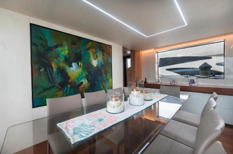 a table with a glass of water and a painting on it aboard RAYEN Yacht for Sale
