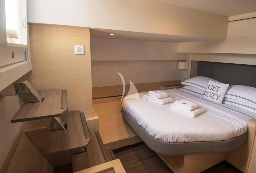 a room with a bed and desk aboard SERENISSIMA Yacht for Charter