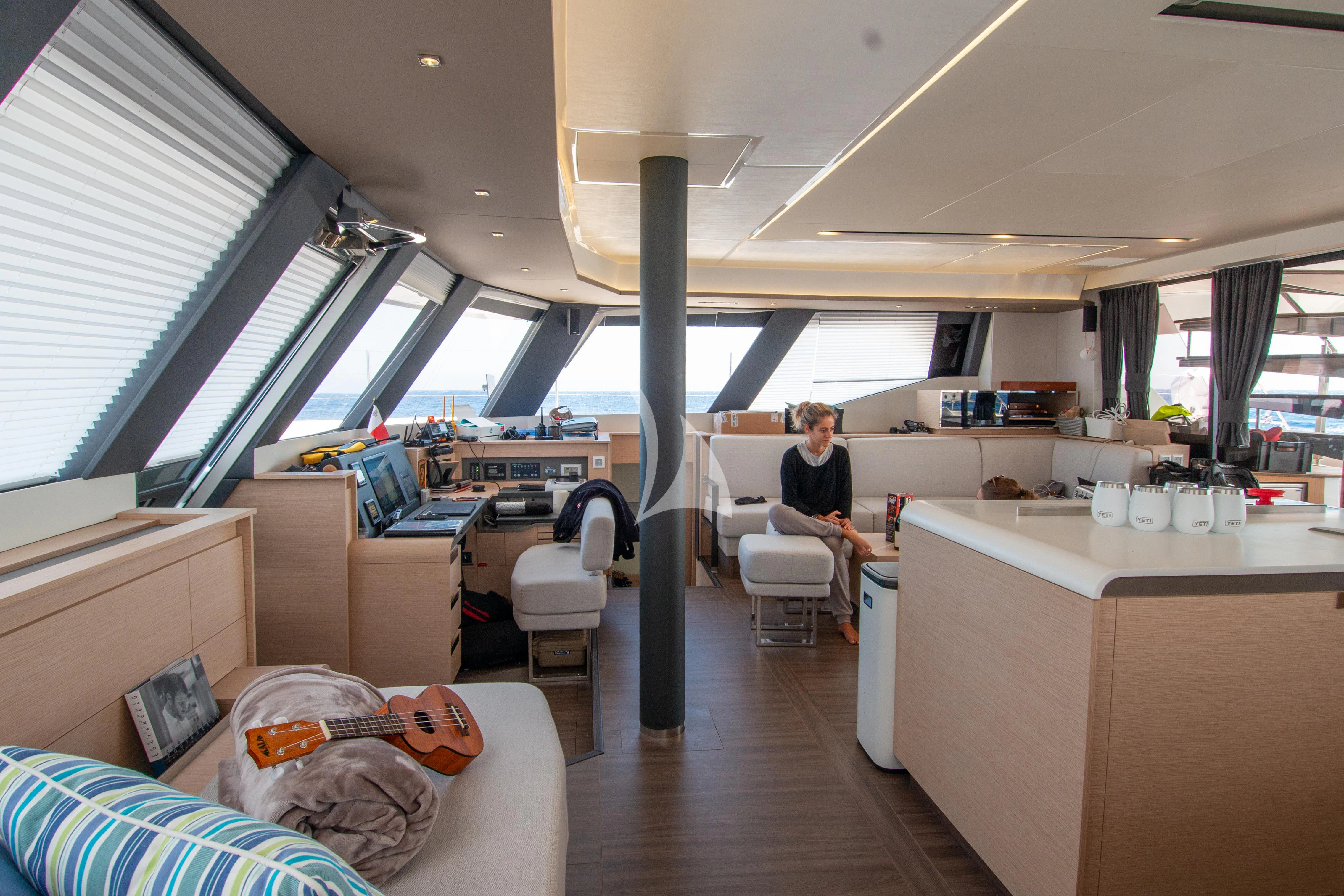 a person sitting in a chair in a room with a table and a couch aboard SERENISSIMA Yacht for Charter