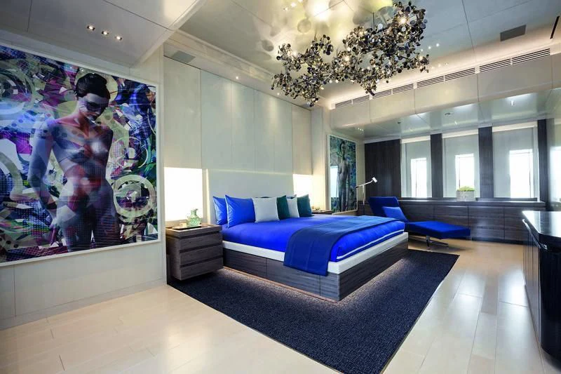 a room with a blue couch and a large painting on the wall aboard SEASENSE Yacht for Sale