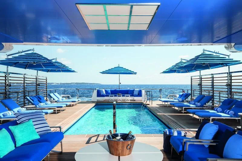 a swimming pool with lounge chairs and umbrellas aboard SEASENSE Yacht for Sale