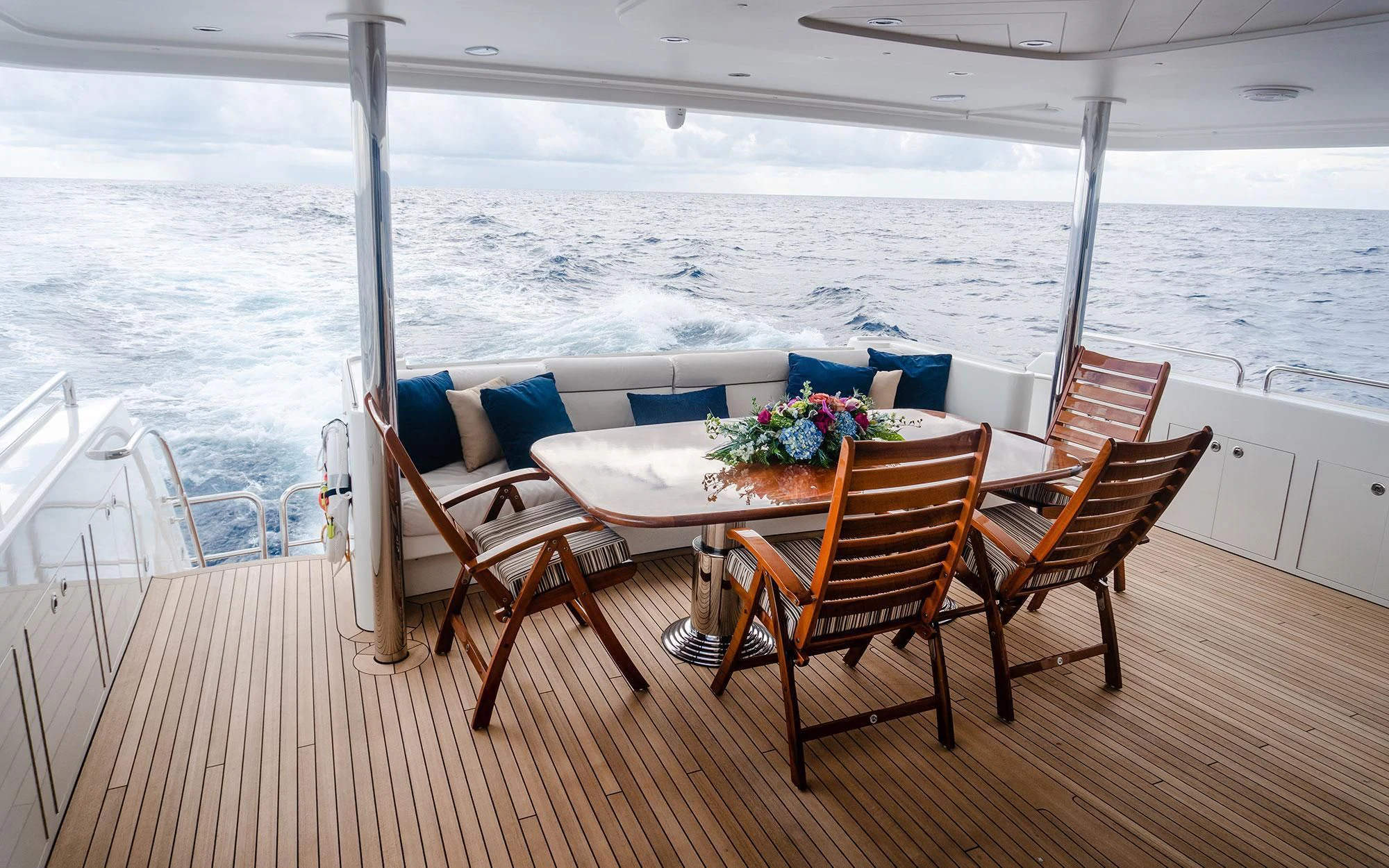 a table and chairs on a deck overlooking a body of water aboard SEASENSE Yacht for Sale