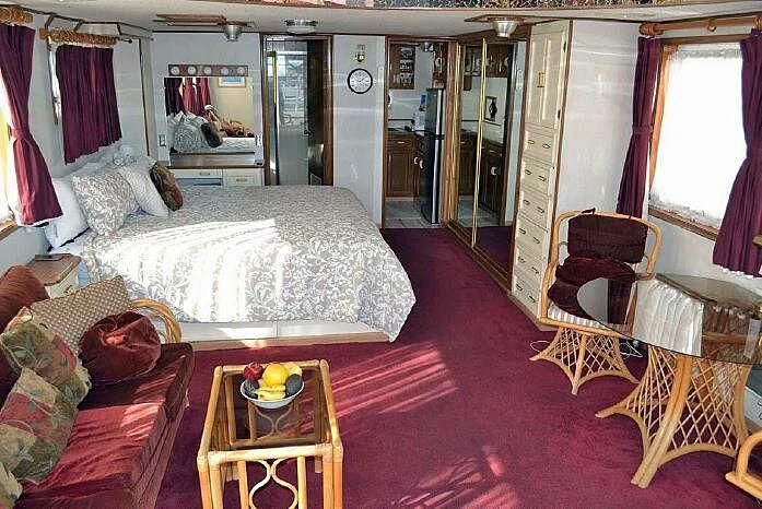 a bedroom with a bed and a table aboard ROSE Yacht for Sale