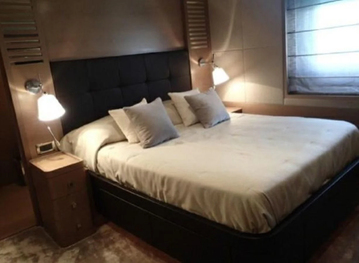 a bed with white sheets aboard BENNETTI 105 Yacht for Sale