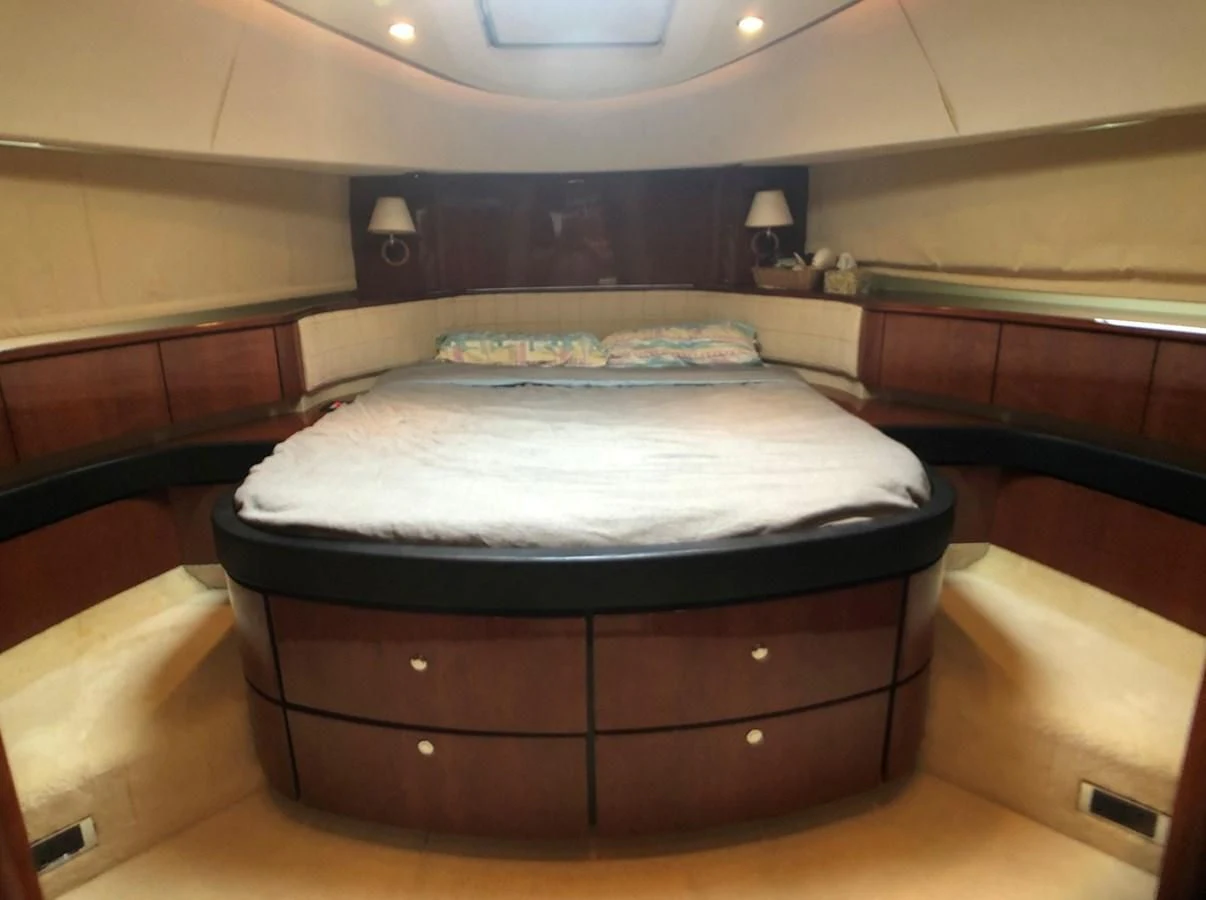 a bed with a blue cover aboard FAIRLINE SQUADRON 74 Yacht for Sale