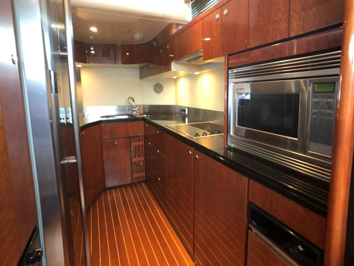 a kitchen with wooden cabinets aboard FAIRLINE SQUADRON 74 Yacht for Sale