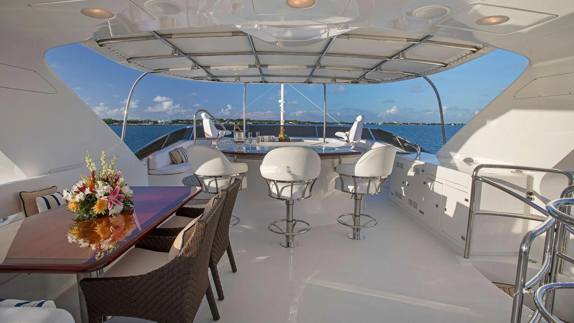 a room with a table chairs and flowers on the floor aboard CRISTOBAL Yacht for Charter