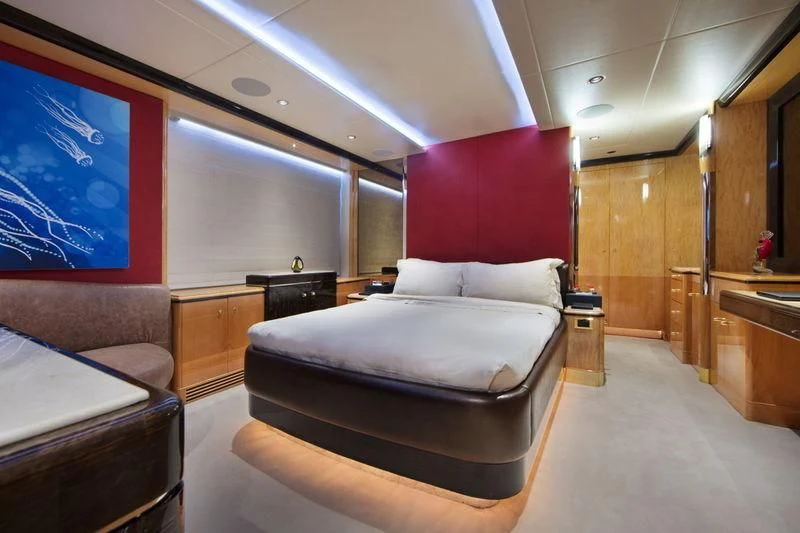 a room with a bed and a red wall aboard CODE 8 Yacht for Sale