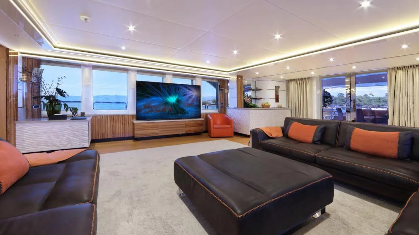 a living room with a large screen aboard CODE 8 Yacht for Sale
