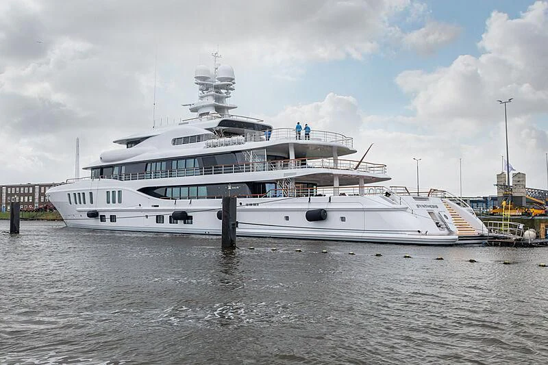 a large white boat in a harbor aboard SYNTHESIS Yacht for Sale